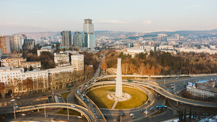 Aerial view of heroes square in tbilisi, georgia, showcasing the bustling traffic navigating the roundabout and surrounding cityscape on a sunny day © wifesun