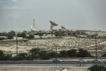 Large satellite dishes and antennas in a desert near Dubai, United Arab Emirates. Concept of space...