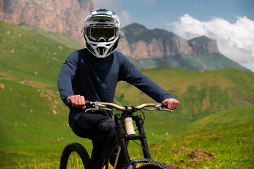 Male athlete cyclist in helmet and protective mask outdoors. MTB rider in mountainous terrain...
