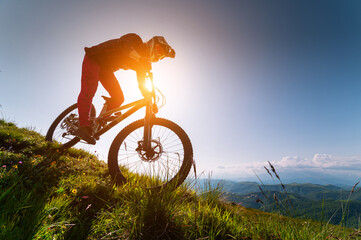 Male athlete cyclist in helmet and protective mask outdoors. MTB rider in mountainous terrain...