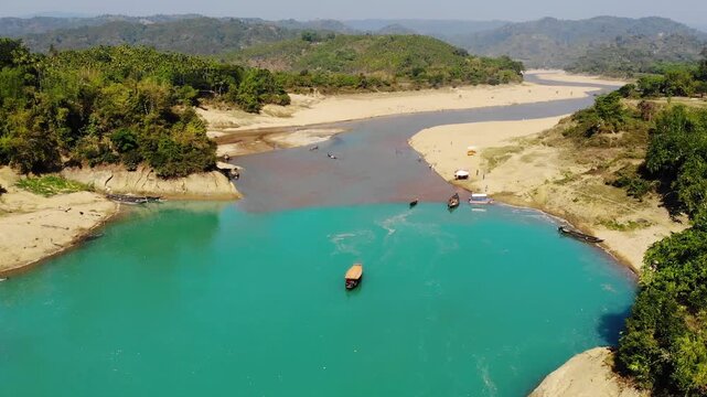 Lala Khal, Bangladesh - 22 August 2025: Aerial view of the mesmerizing Lala Khal river where turquoise waters meet sandy shores, dotted with boats and lush greenery.