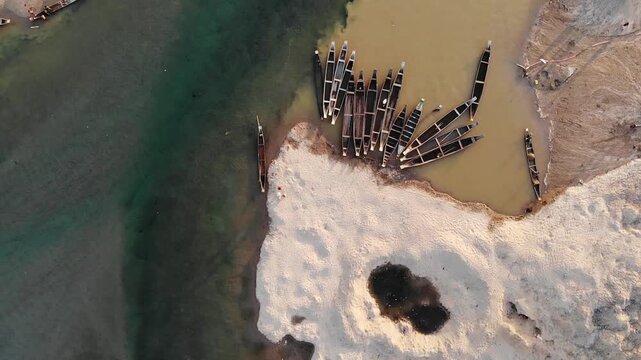 Jaflong, Bangladesh - 21 August 2025: Aerial view of numerous boats clustered near the shore, contrasting with the sandy riverbank and the flowing river.