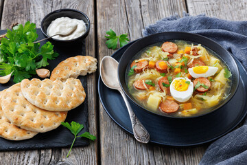 Polish sauerkraut soup with sausage in a bowl