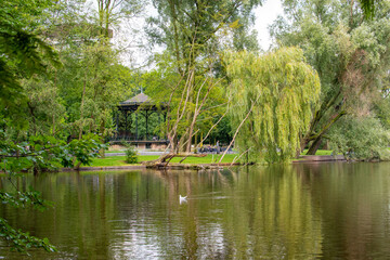 Obraz premium A beautiful landscape picture of a small lake in a park in Amsterdam, Netherlands; with mirror reflection on the water.