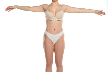 Studio shot of young woman in underwear standing with arms outstretched on white background.