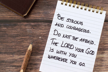 Inspirational Christian quote for God's strength and protection handwritten in notebook with holy...