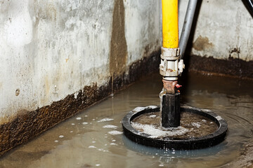 Basement sump pump in action removing water from flooded area