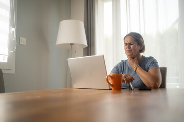 Sick woman with sore throat working on laptop from home remote job