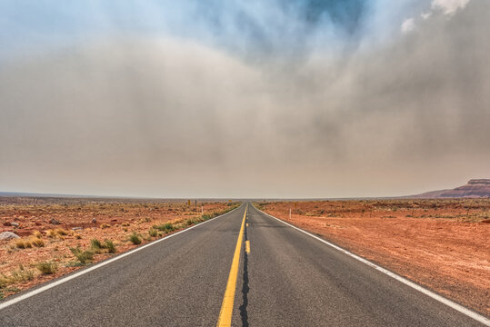 Straight road with Smoke from the Dragon Bravo Wildfire at the Grand Canyon obscuring the Kaibab Plateau, Arizona, USA
