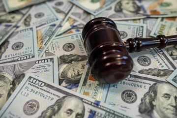 Judge's gavel on pile of US dollar bills – Concept of justice, corruption, bribery or court fines