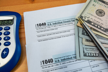 Money and calculator on U.S. tax documents for financial planning and income declaration