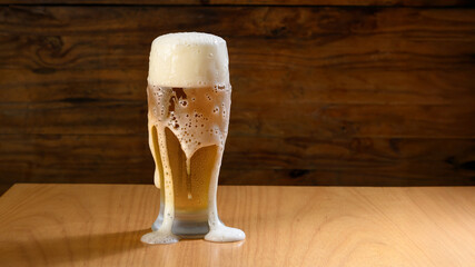 Overflowing Beer Glass on Wooden Table