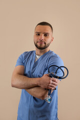 Young doctor man in blue uniform with stethoscope posign at studio. Medical worker