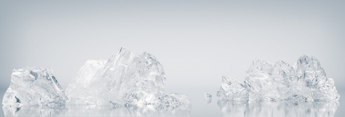 Natural, crystal clear crushed ice cubes on a white reflective surface background.