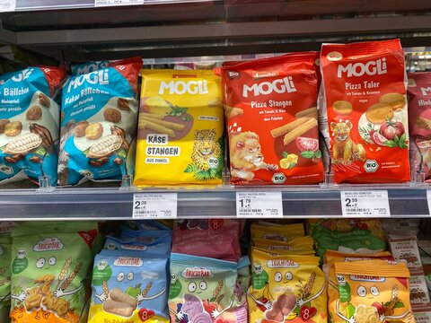 Santa Ponsa, Spain - August 20, 2025: Colorful assortment of organic snacks from Mogli brand displayed on supermarket shelf, showcasing various flavors and packaging for healthy eating options