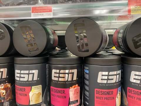 Santa Ponsa, Spain - August 20, 2025: ESN Elite Sports Nutrition protein powder containers stacked on supermarket shelf, showcasing vibrant packaging and product variety for fitness enthusiasts