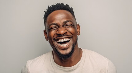 handsome unshaven young darkskinned male laughing out loud at funny meme he found on internet smiling broadly showing his white straight teeth positive human facial expressions and emotions no logos 