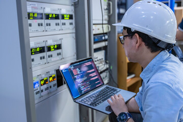 Electrical engineer male checking voltage at the Power Distribution Cabinet in the control room,preventive maintenance Yearly,inspecting power system and control panel in industrial factory