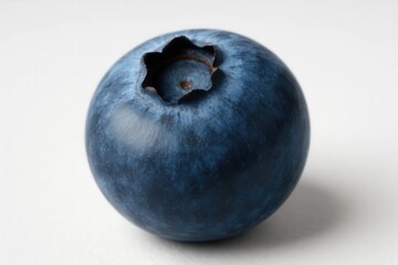 Obraz premium A single blueberry rests on a pristine white surface, its vibrant color contrasting sharply with the surrounding simplicity