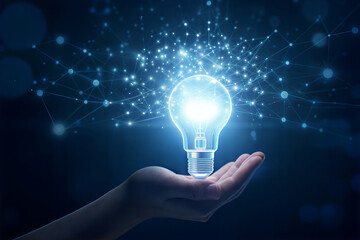 Bright glowing lightbulb held in an open hand symbolizing innovation inspiration and new ideas with a sparkling blue energy burst