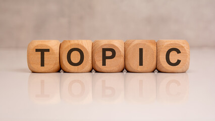 Wooden cubes with word TOPIC on white background, concept of subject or discussion theme