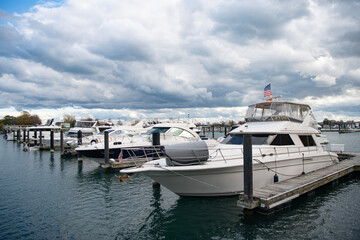 Fototapeta premium Yacht charter. Sea vacation on summer. Luxury boat motor yacht in marina. Luxury yacht docked in marina sea. Boating and yachting tourism. Luxurious lifestyle. Summer vacation