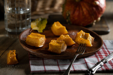 Baked pumpkin pieces on a wooden plate