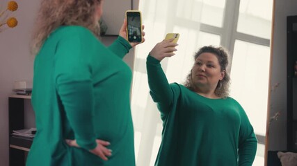 Attractive plus size woman taking selfie in front of mirror, body positivity