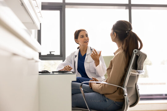 Positive female general practitioner giving consultation, medical advice to patient