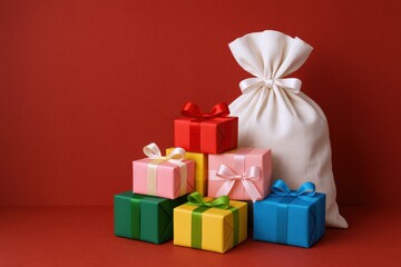 Obraz premium Festive Gift Boxes and Sack on Red Background, Christmas Holiday Celebration Still Life