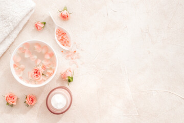 Spa and beauty routine concept with pink roses and essence water with petals