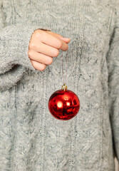 Hand holding shiny red Christmas bauble