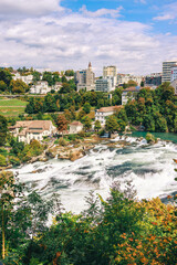 Majestic view of Rhine Falls, the largest waterfall in Europe, located near Schaffhausen in northern Switzerland. Powerful cascades of water rush over rugged rocks, surrounded by lush greenery and mis © Breg