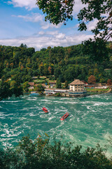 Majestic view of Rhine Falls, the largest waterfall in Europe, located near Schaffhausen in northern Switzerland. Powerful cascades of water rush over rugged rocks, surrounded by lush greenery and mis © Breg