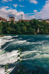 Majestic view of Rhine Falls, the largest waterfall in Europe, located near Schaffhausen in northern Switzerland. Powerful cascades of water rush over rugged rocks, surrounded by lush greenery and mis © Breg