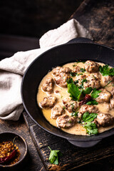 Meatballs in sour cream sauce in a frying pan