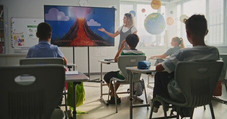 Elementary School Students Studying Basic Information About Geology in Modern Classroom. Female...