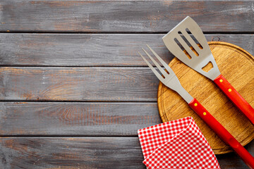 Set with barbecue utensils and equipment with red picnic napkin. Stainless steel tools. Top view
