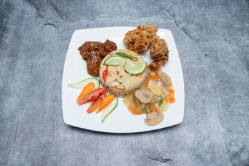 Fried Rice Set with Crispy Fried Chicken, and Fresh Vegetables in plate top view of savory lunch
