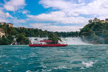 Majestic view of Rhine Falls, the largest waterfall in Europe, located near Schaffhausen in northern Switzerland. Powerful cascades of water rush over rugged rocks, surrounded by lush greenery and mis © Breg