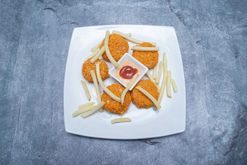 Classic Chicken Nuggets and French Fries with Dipping Sauce on a Plate top view of fast food