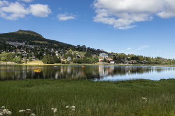 Summer evening view with beautiful light, of Lac des Hermines (lake) at Super Besse ski resort, near Besse-et-Saint-Anastaise, in France. Copy space above and below.