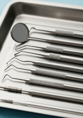 Dental tools are arranged cleanly on a metal tray, demonstrating precision in dentistry and hygiene in a medical setting.