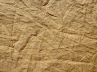 wrinkled brown linen fabric closeup with natural fold texture perfect for vintage background or rustic textile design