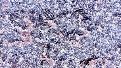 rough granite stone surface with blue gray mineral texture and pink quartz veins for natural background or geology design