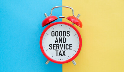 A red alarm clock with the words goods and service tax written on it