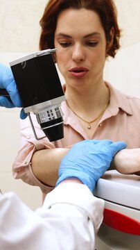 Vertical video. Trichologist conducts close-up examination in medical center. Concept of innovative technology for precise diagnostics of hair and skin health.