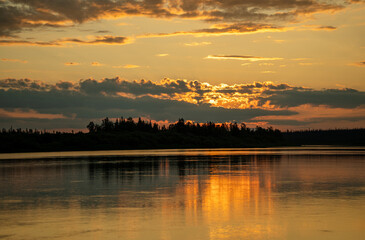 Golden sunset over black forest near lake
