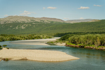 A winding river among the forest and mountains on the horizon