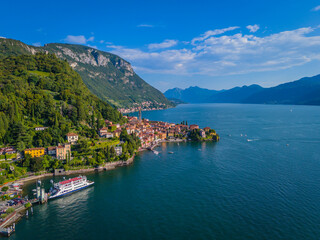Fototapeta premium Varenna, Como lake. Picturesque village in Lombardy, Italy. Aerial panoramic drone view of beautiful town with colorful houses surrounded by mountains